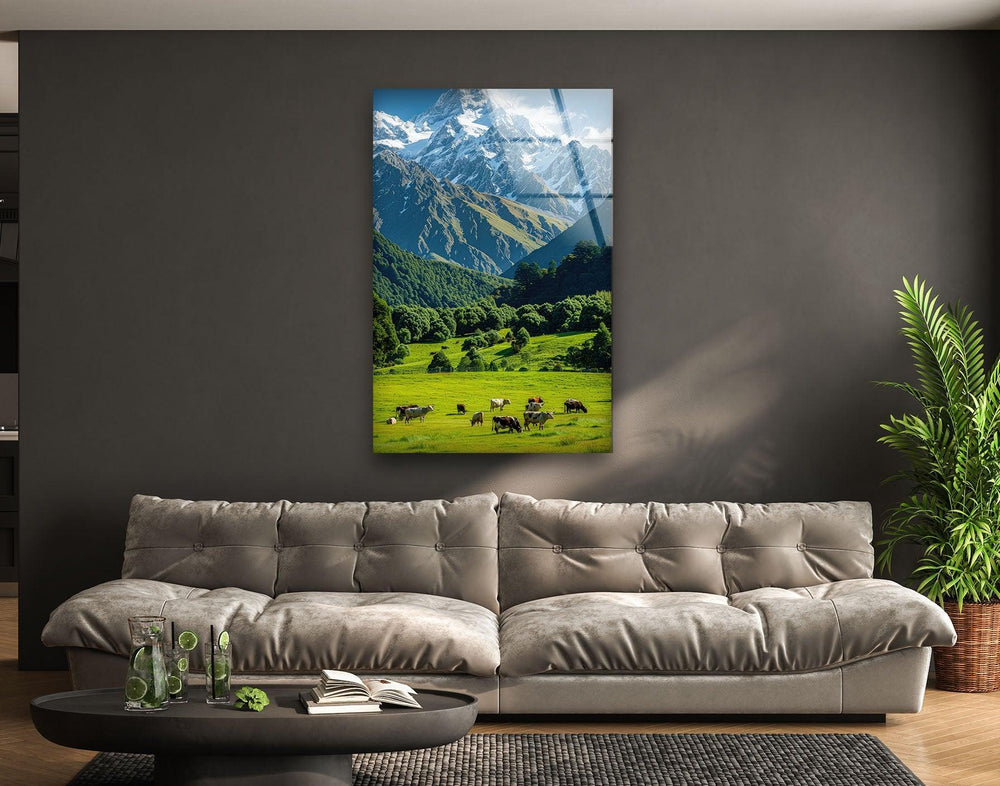 Stunning mountain landscape featuring lush green fields, grazing cows, and majestic peaks.