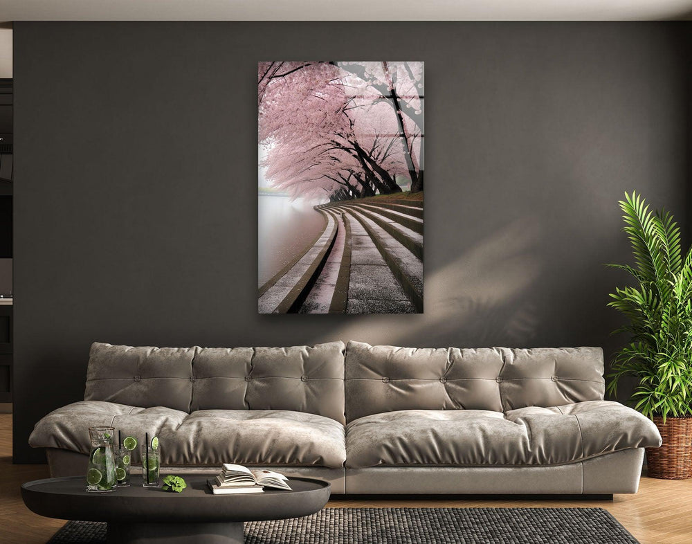 A tranquil spring scene featuring a curved pathway lined with blooming cherry blossom trees.