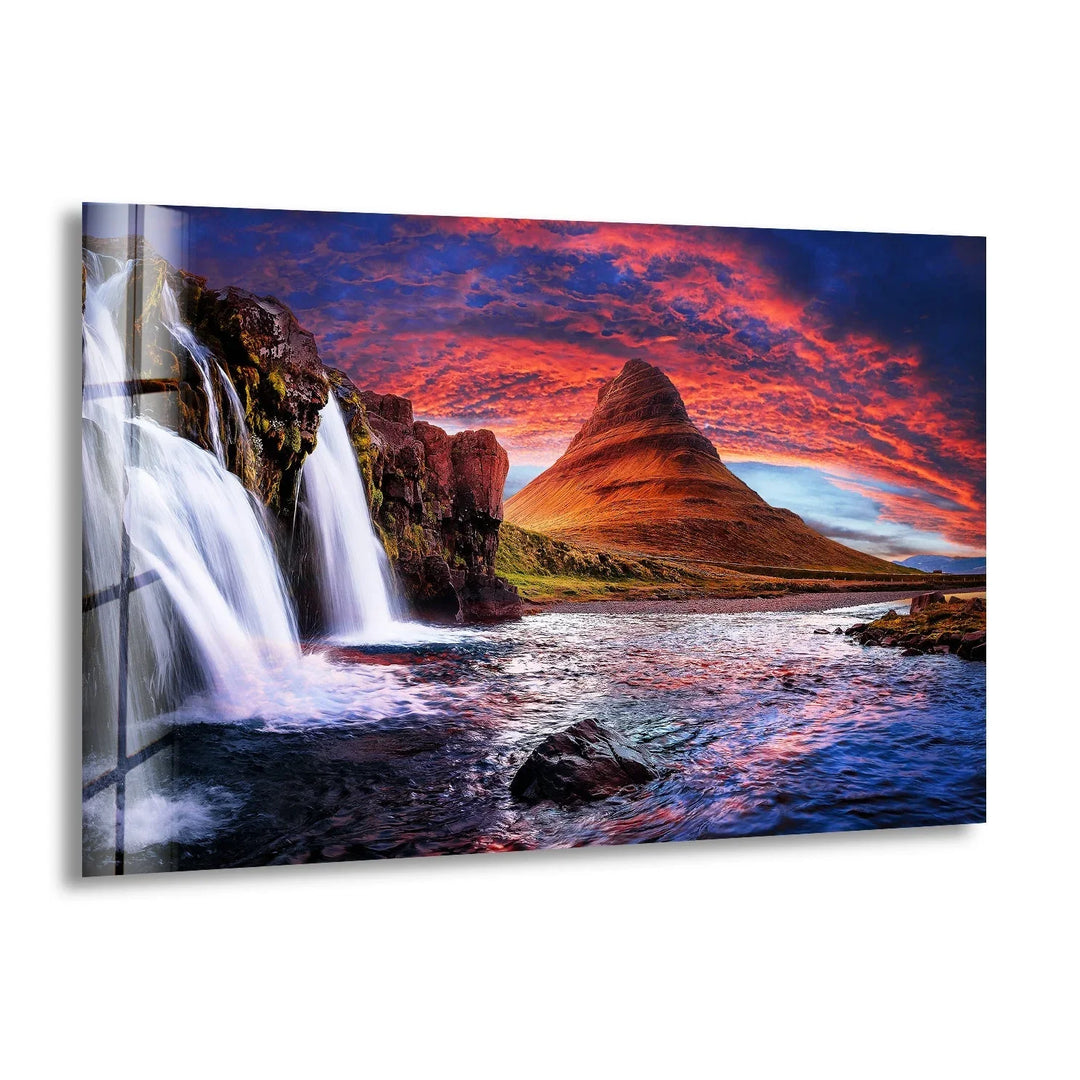 Breathtaking waterfall cascading into a river under a dramatic sunset sky, printed on glass wall art.