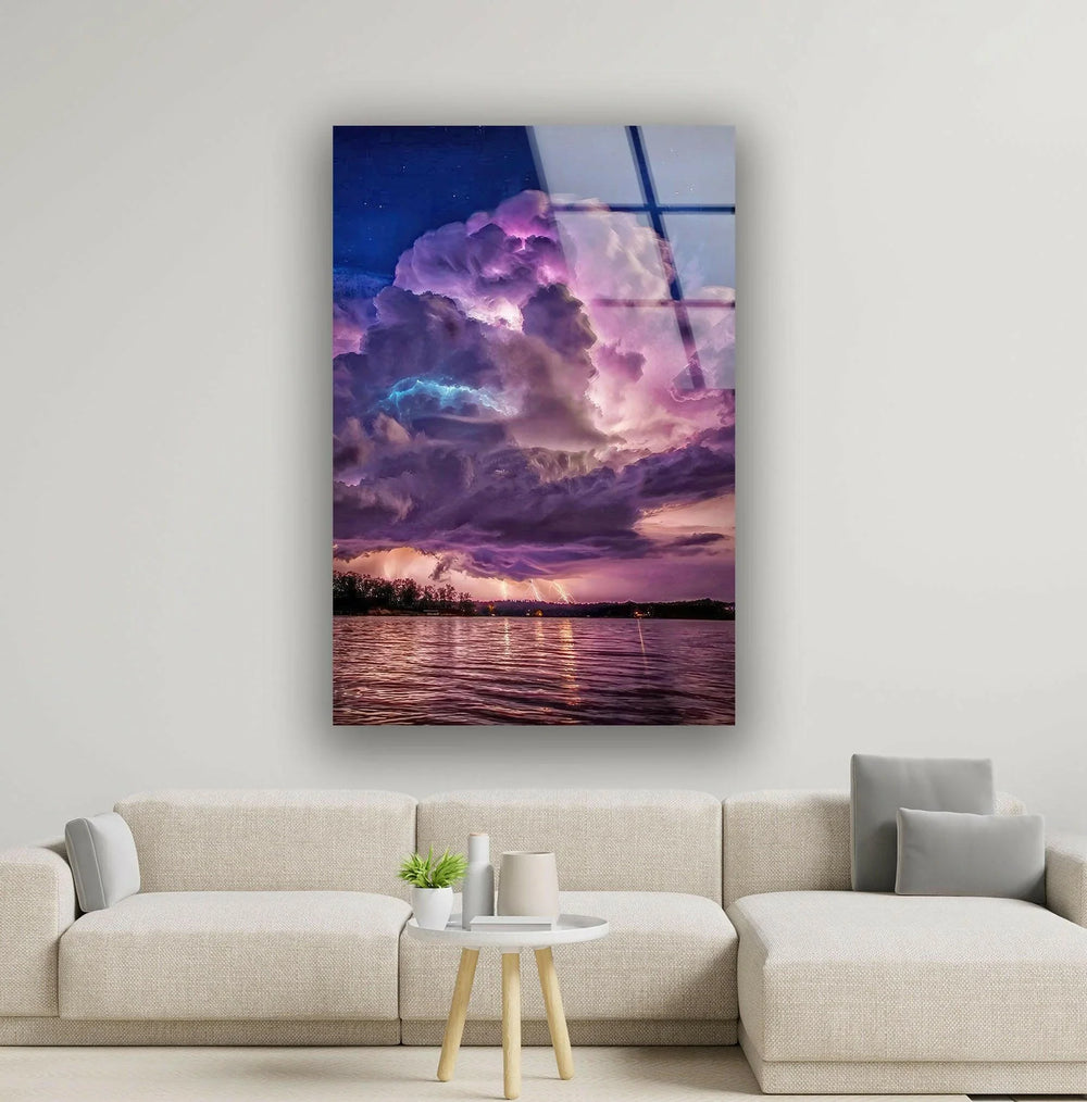 Breathtaking stormy sky with vibrant purple and blue clouds reflecting on water.