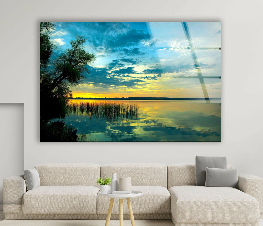 Serene lake scene at sunset with golden hues and calm water reflections on glass.