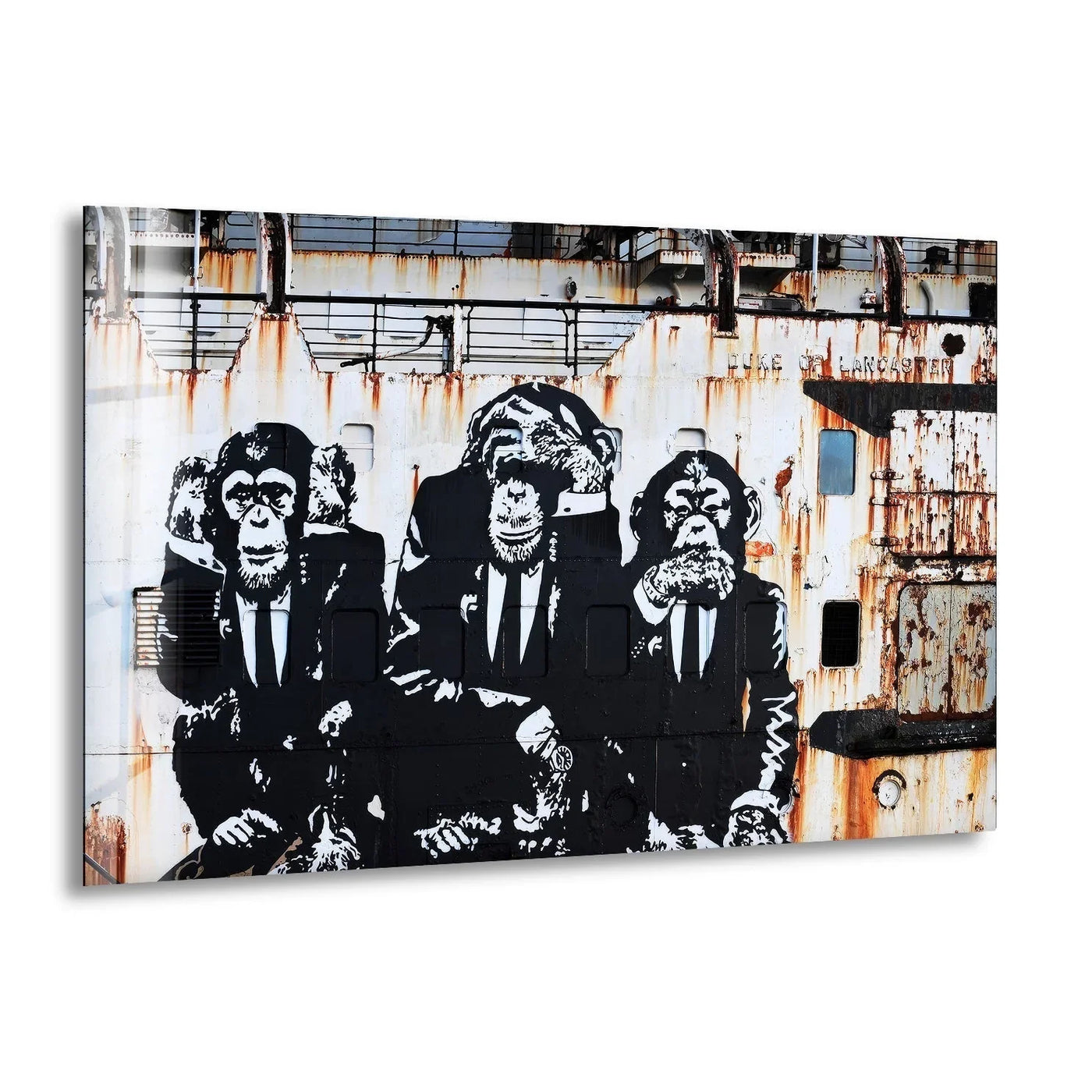 Three geometric monkey figures in suits are stenciled on the side of a rusty, industrial ship, creating unique decorative wall art.