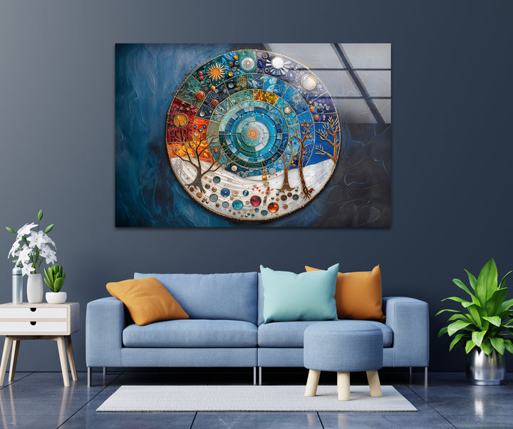 Plush blue sofa, ottoman, and wooden side table with plants define the foreground, leading to the striking abstract glass art painting.
