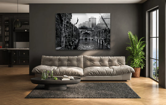 Negative space surrounds a captivating image of old Delhi ruins, displayed as distinctive glass wall art decor, contrasting starkly with the room's furnishings.