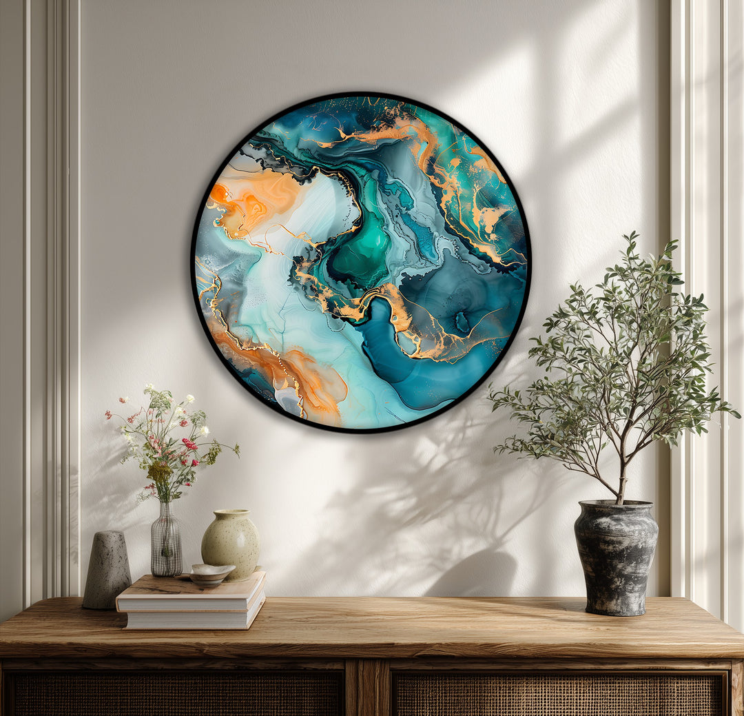 Fluid marble patterns coalesce in this abstract canvas pictures of teal, gold, and emerald, creating unique, round modern wall art.