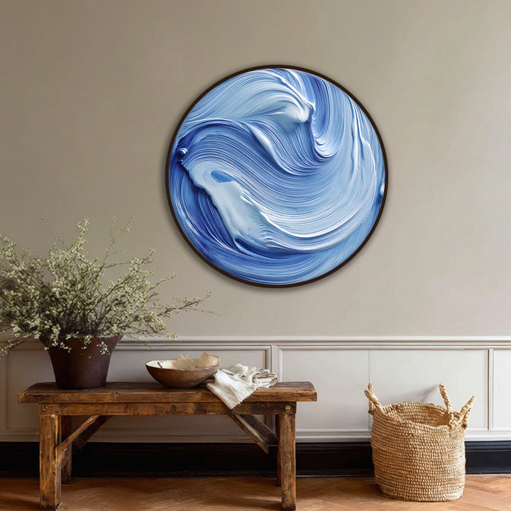 Visually striking abstract canvas painting depicts an ocean flow of swirling blue and white waves, capturing the modern and fluid nature of the round wave wall art.
