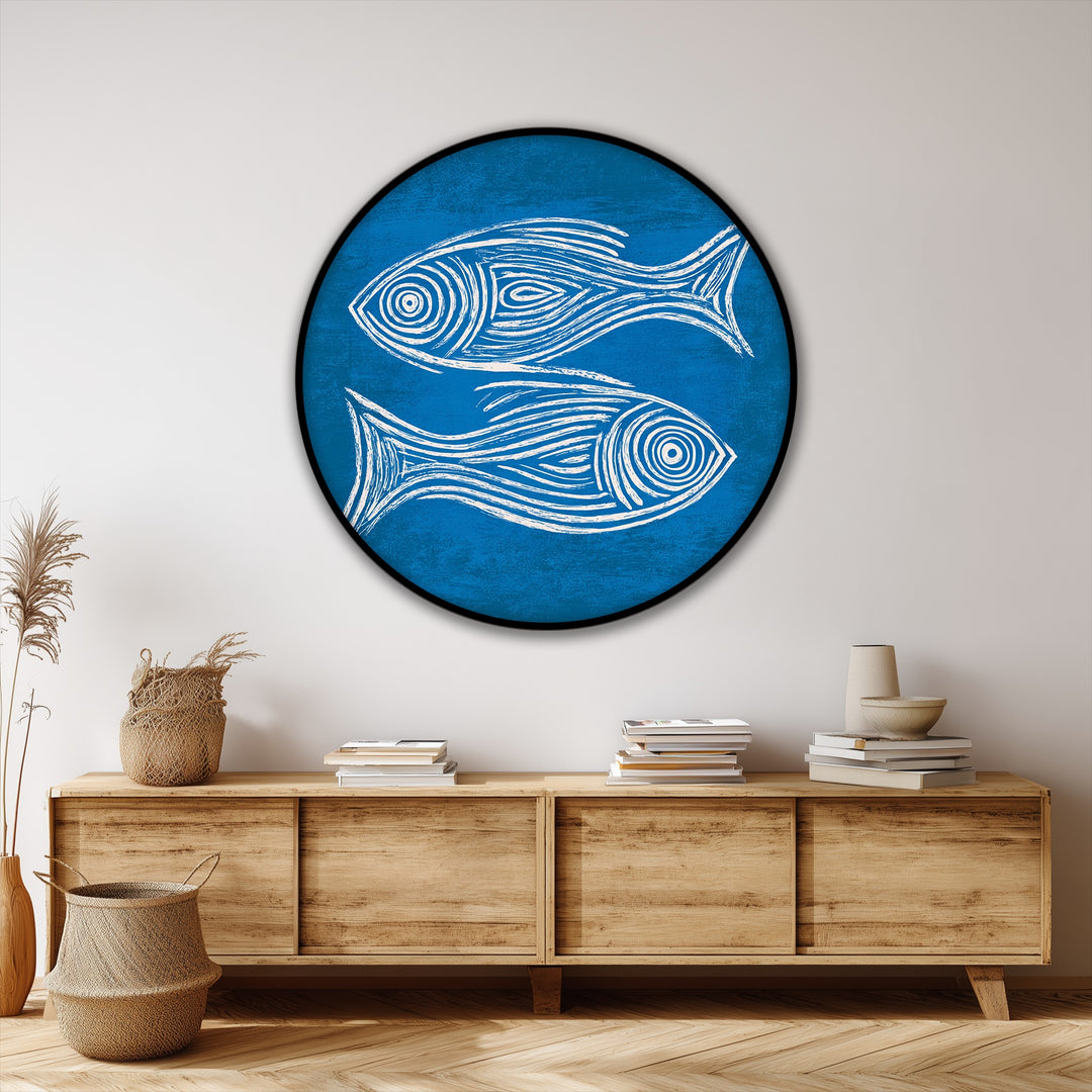 The circling dance of the two minimal fish creates a vibrant sense of motion in this blue round framed canvas print, a piece of coastal wall art.