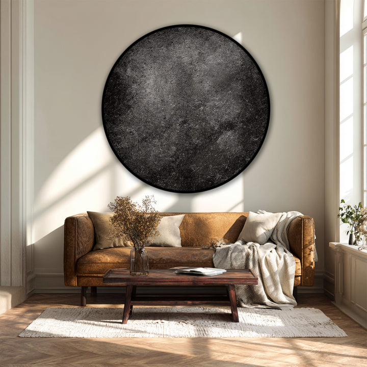 Sunlight creates distinct light and shadow patterns that play across this modern black round canvas art print, enhancing the dark texture and minimal design of this canvas art.