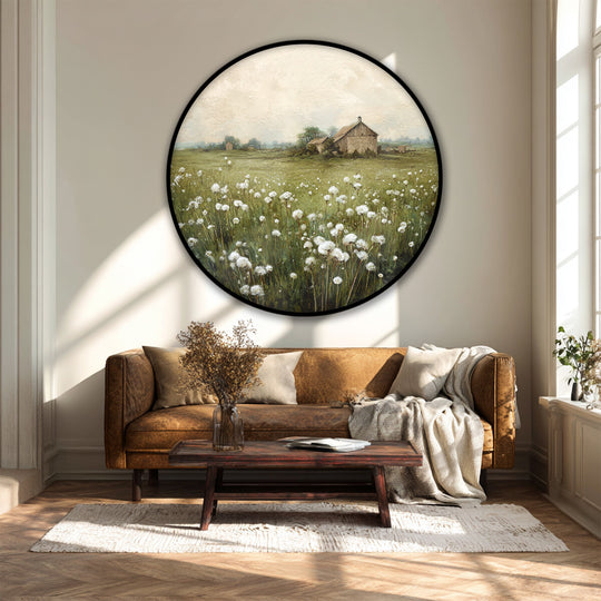 Sunlight casts long shadows across the wall highlighting the round canvas artwork featuring a rustic barn and countryside meadow landscape.