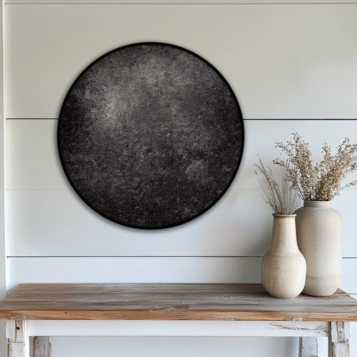 The darkest area accentuates the texture of the round canvas wall decor on this dark textured minimal canvas print, contrasting with the lighter surroundings.