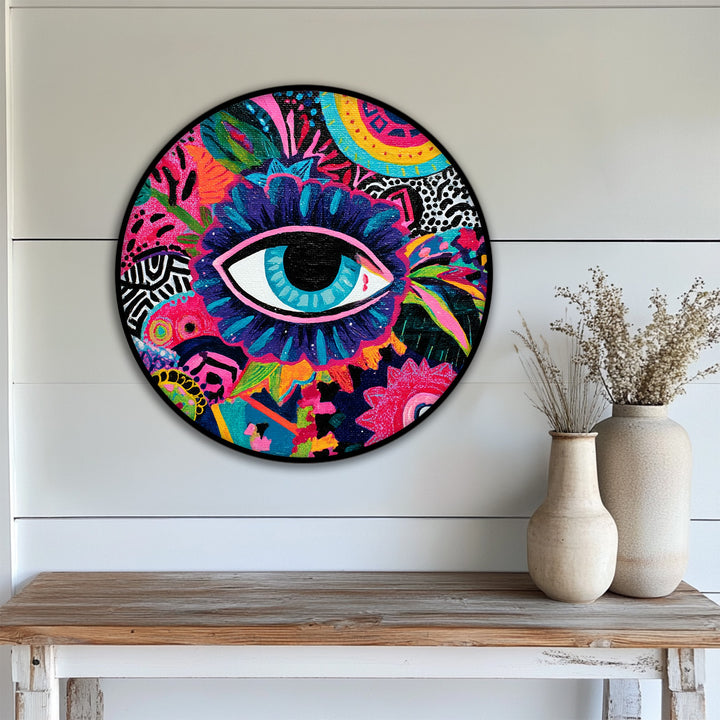 Circular canvas wall art features geometric shapes and patterns surrounding a central eye in a vibrant, colorful pop art design.