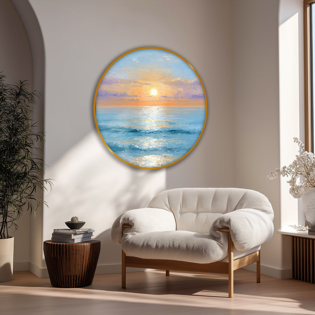 The foreground features a cozy, cushioned armchair situated beneath a serene, circular canvas print depicting a golden sunrise over the ocean, showcasing one of the best canvas prints.