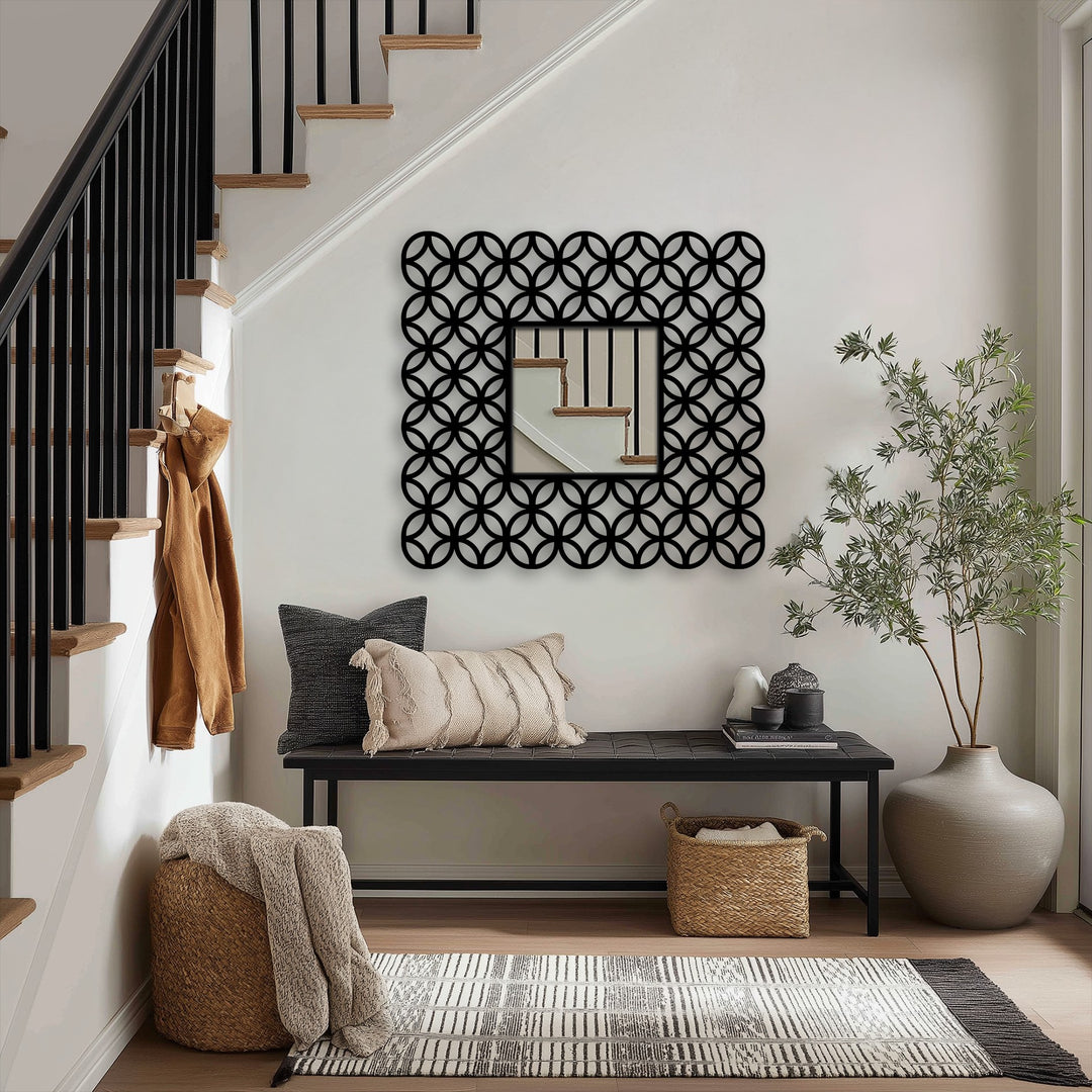 Framed by the interlocking ring pattern, the decorative mirror subtly reflects the staircase's color transition from dark metal to warm wood, offering modern metal art for wall ambiance.