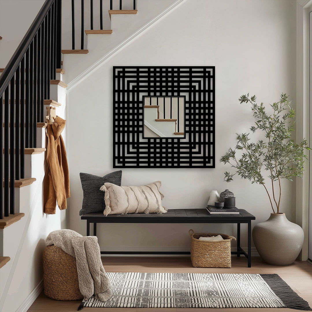 Set against a bright entryway, a geometric frame mirror showcases the blurred reflection of a staircase, enhancing the stained glass wall mirror aesthetic.