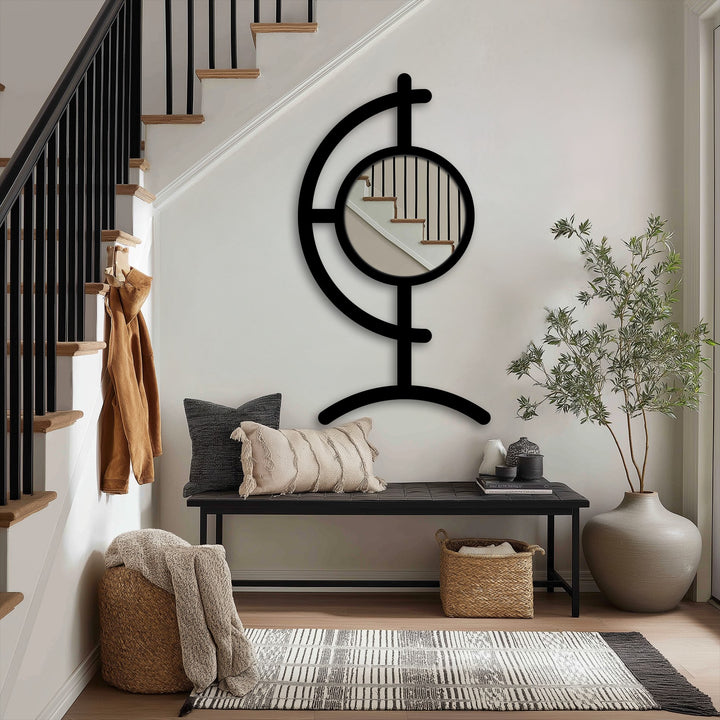 Sculptural black metal floor mirror showcases a modern design with its round center reflecting the staircase, making it a unique metal wall art focal point.