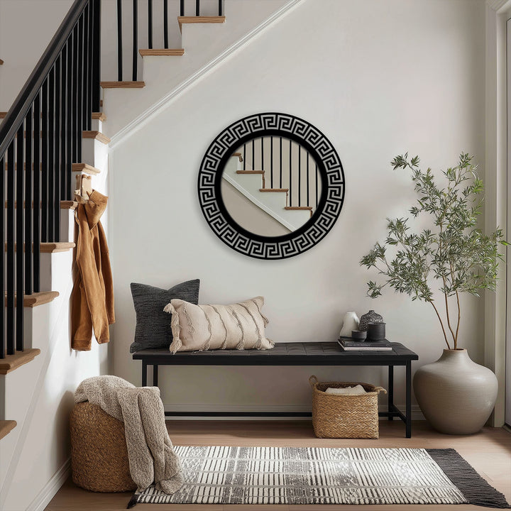 The darkest area highlights the sleek black frame of a modern wall mirror, reflecting the staircase above a stylish black upholstered bench.