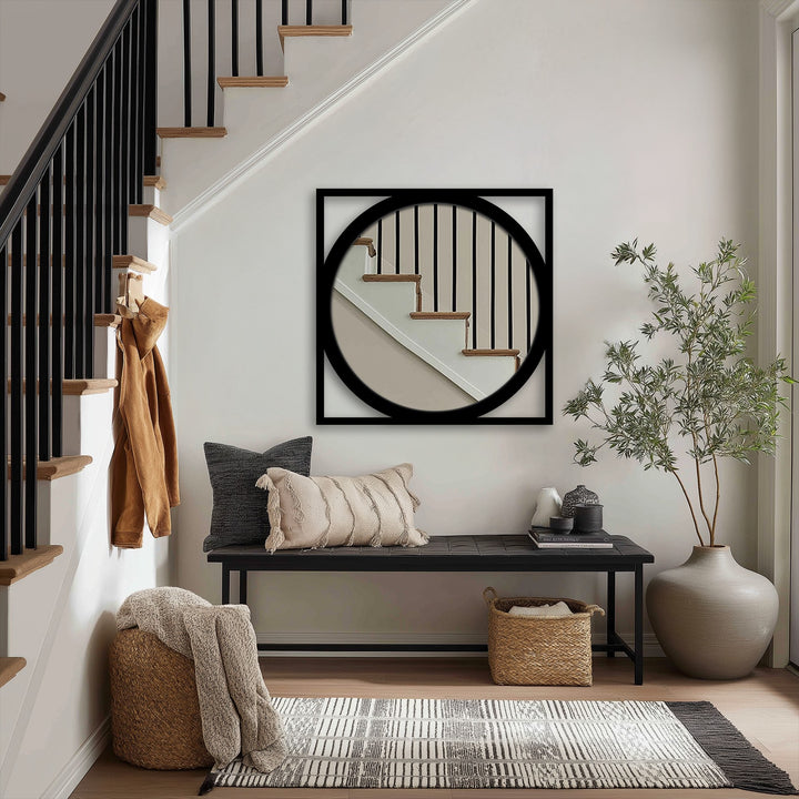 Foregrounding the loudest element, this modern black metal frame mirror displays the unique metal wall art's square outline and round reflection, adding minimalist design to the interior.