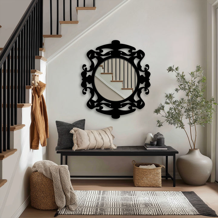 Light and shadow play across the ornate black metal frame of the modern mirror, reflecting the stairway and nearby decor with subtle gradations.