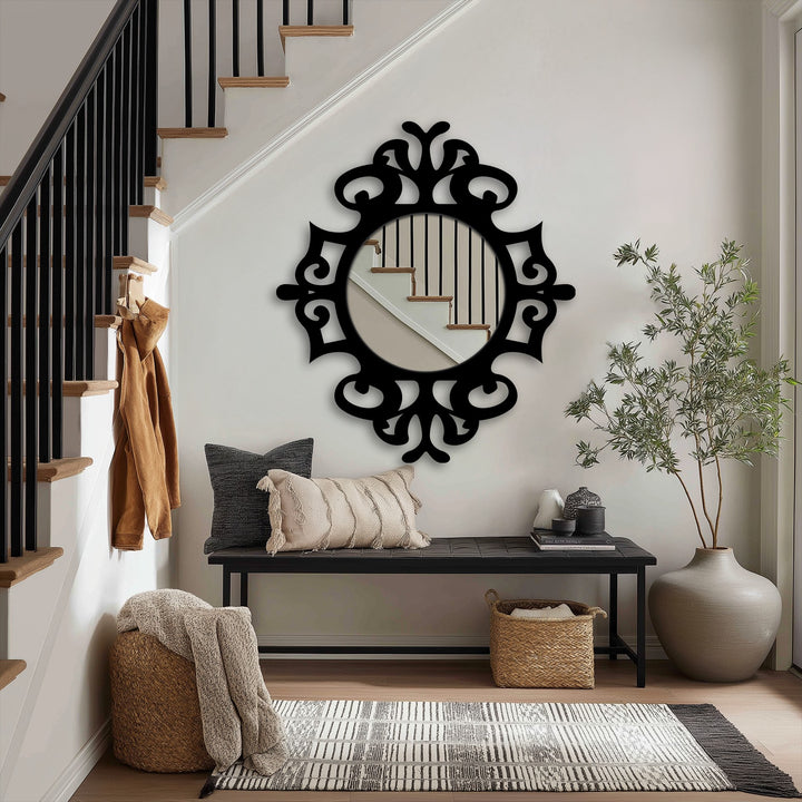 Black ornate frames define the darkest area around a decorative round stained glass wall mirror reflecting stairs in an elegant entryway.