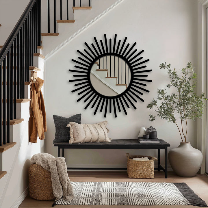 Inviting entryway presents a warm and stylish mood with a sunburst round mirror for wall decor, reflecting the staircase with a sleek black frame.