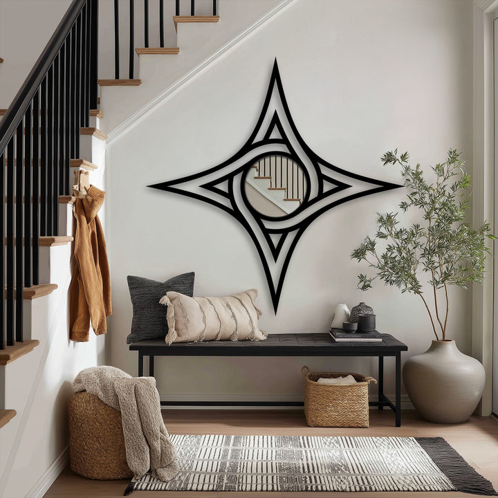 Negative space highlights the geometric star frame revealing the mirror for wall decor in an entryway that features a staircase within its circular center.