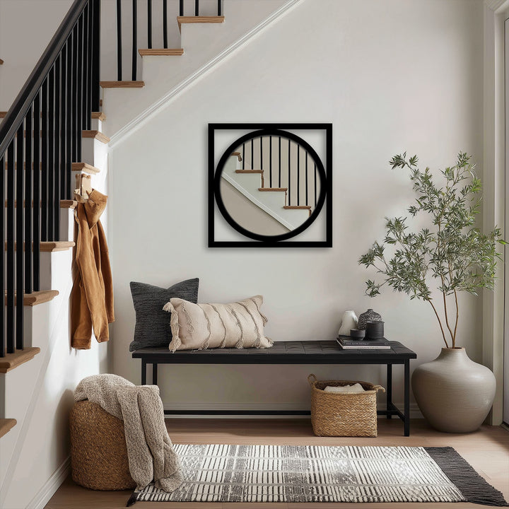 Black framed square mirror with round interior presents a captivating display, showcasing unique metal wall art as the loudest element in a modern entryway.