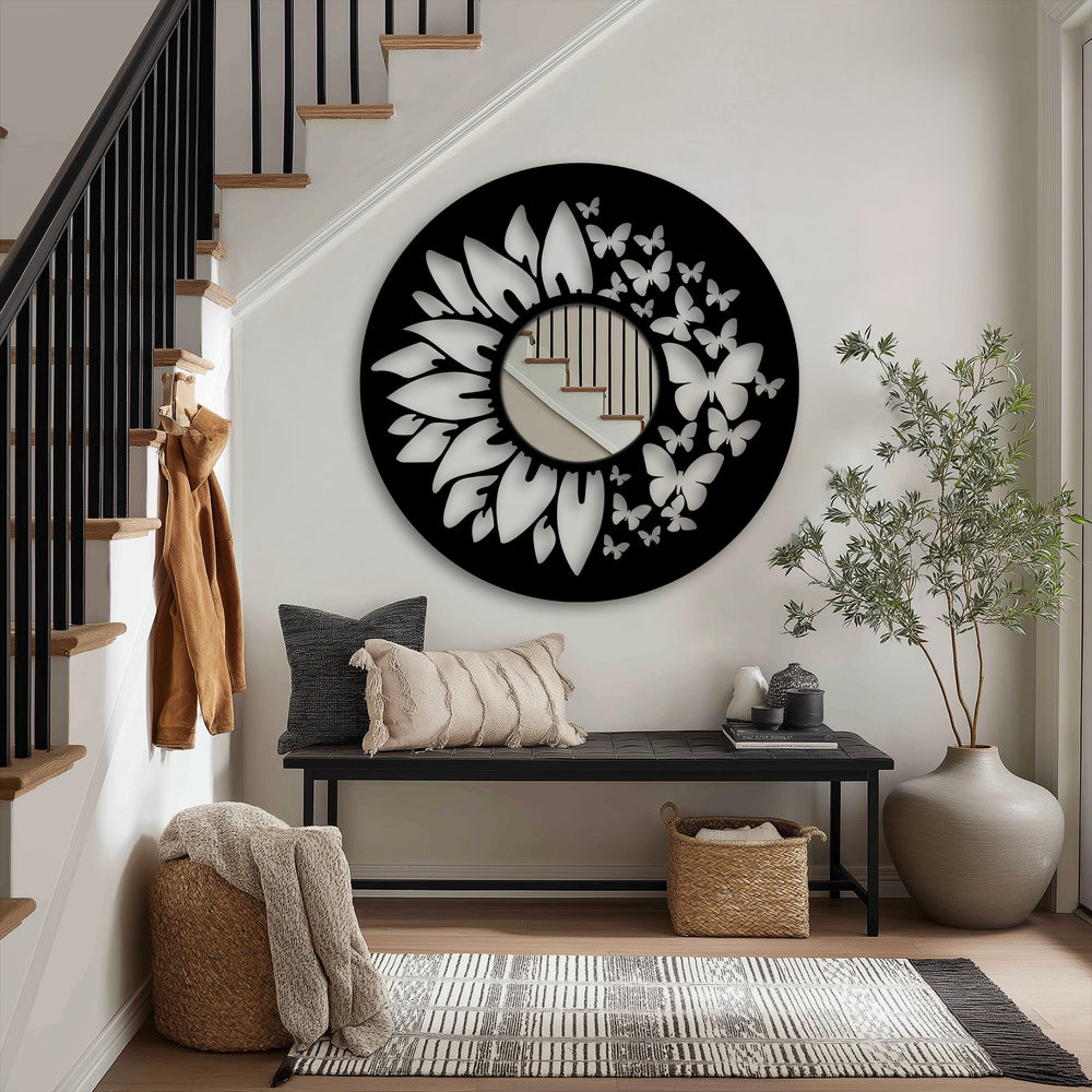 Framed wall mirror featuring a decorative black metal edge and borders fashioned in a butterfly and sunflower design around the reflective surface.