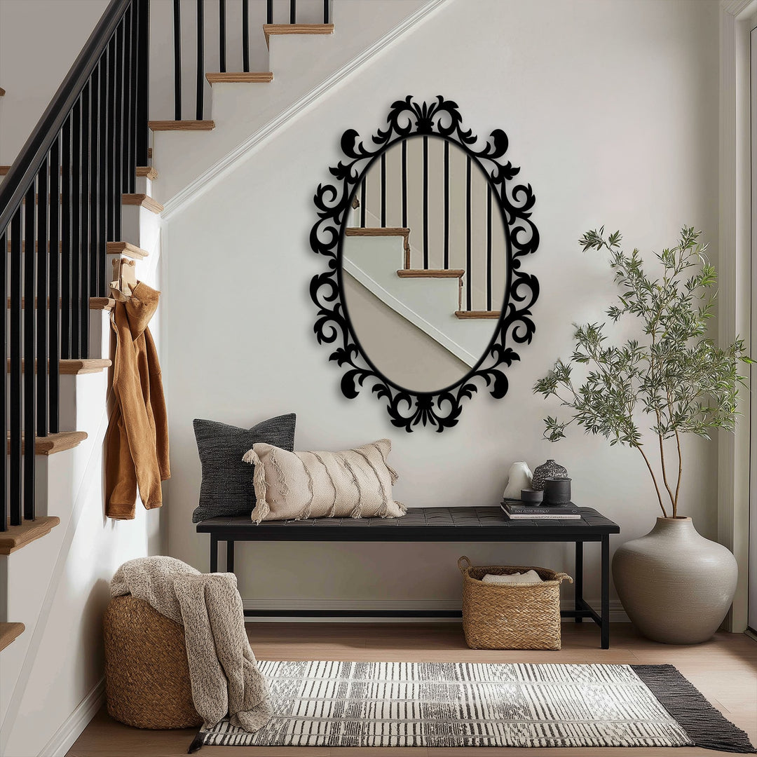 Ornate framed wall mirror in an oval shape is the focal point, reflecting the staircase and adding elegance to the hallway.
