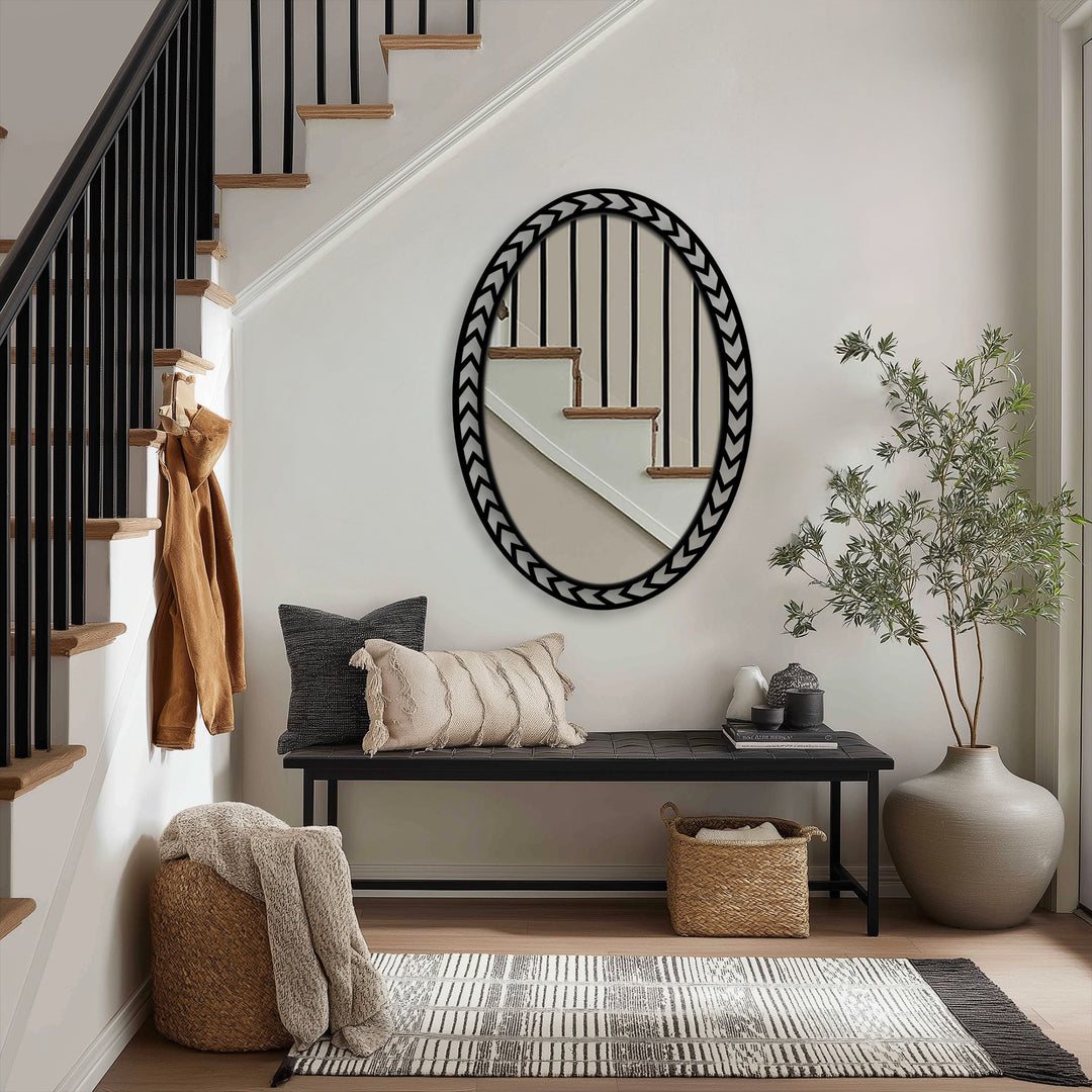 Dramatic color contrast defines the chevron edge oval floor mirror's reflective surface against the black and gray of the metal artwork frame.