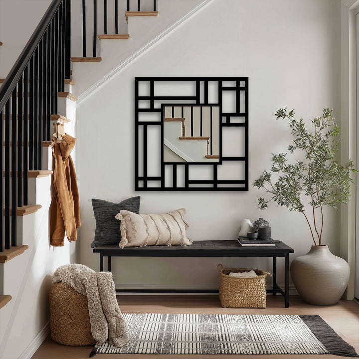 Cream-colored fringed cushion offers a soft contrast to the geometric Structured Grid metal mirror for wall decor in an entryway, with its modern design.