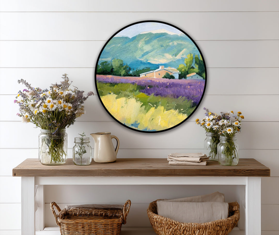 Abundant wildflowers in mason jars and a rustic pitcher grace the shelf beneath the circular oil painting reproduction print of a lavender field.