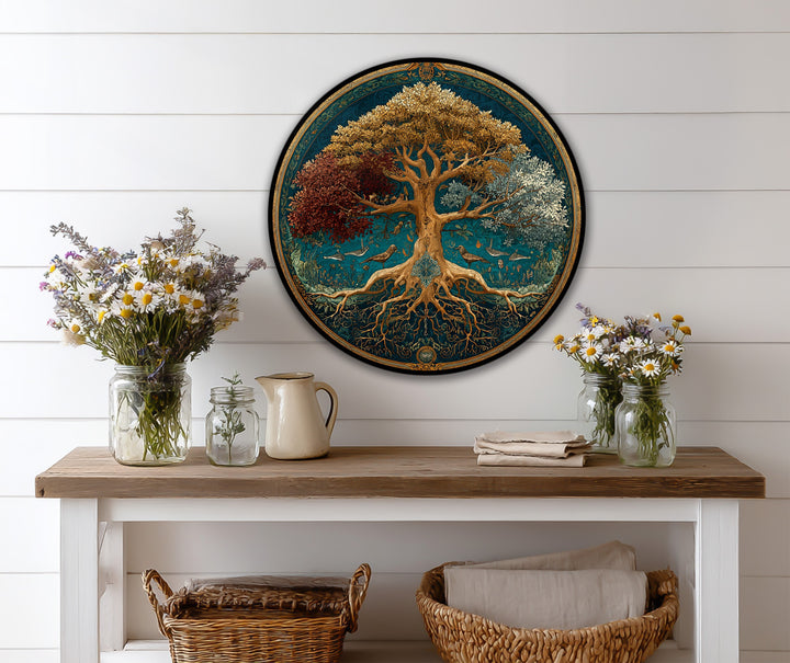 Dominated by a teal background, the tree of seasons circular oil painting decoration showcases a symbolic tree with roots and birds.