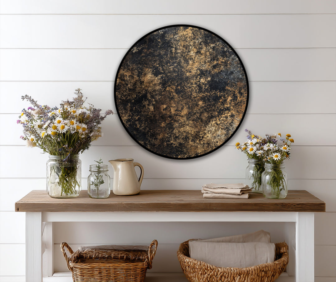Softly illuminated daisies enhance the textured black and gold of the round oil painting art prints, creating a gentle contrast on the white shiplap.