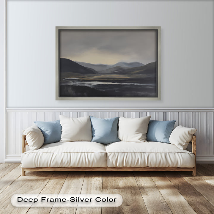 A silent river flowing in front of distant blue mountains, with dark plains creating a melancholic atmosphere.

