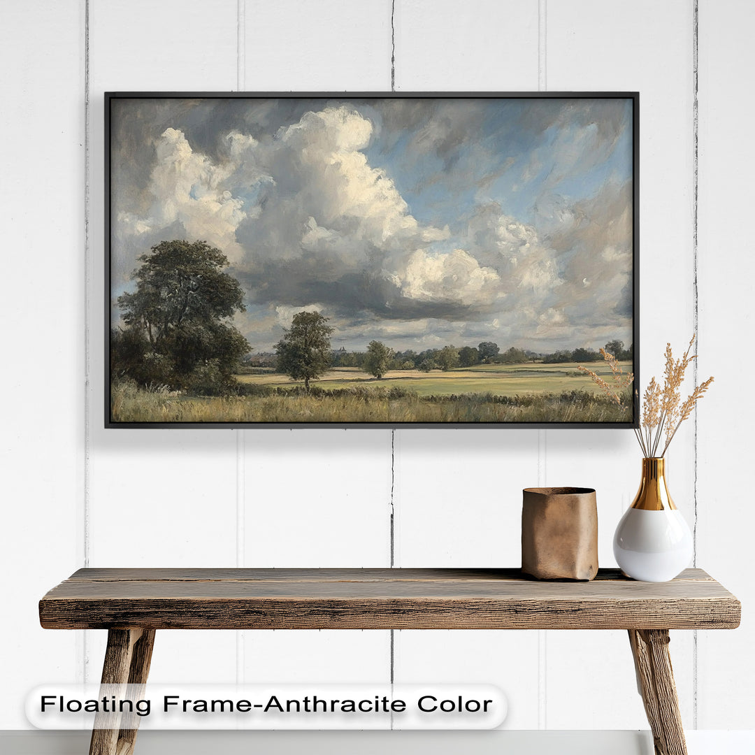 A vast countryside stretches beneath a dramatic sky, where billowing clouds cast shifting shadows over golden fields and scattered trees in this stunning landscape painting.