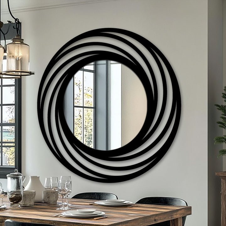 Smooth, layered surface texture defines the swirling rings circle decorative mirror, which showcases a modern black metal frame around a round reflective center.