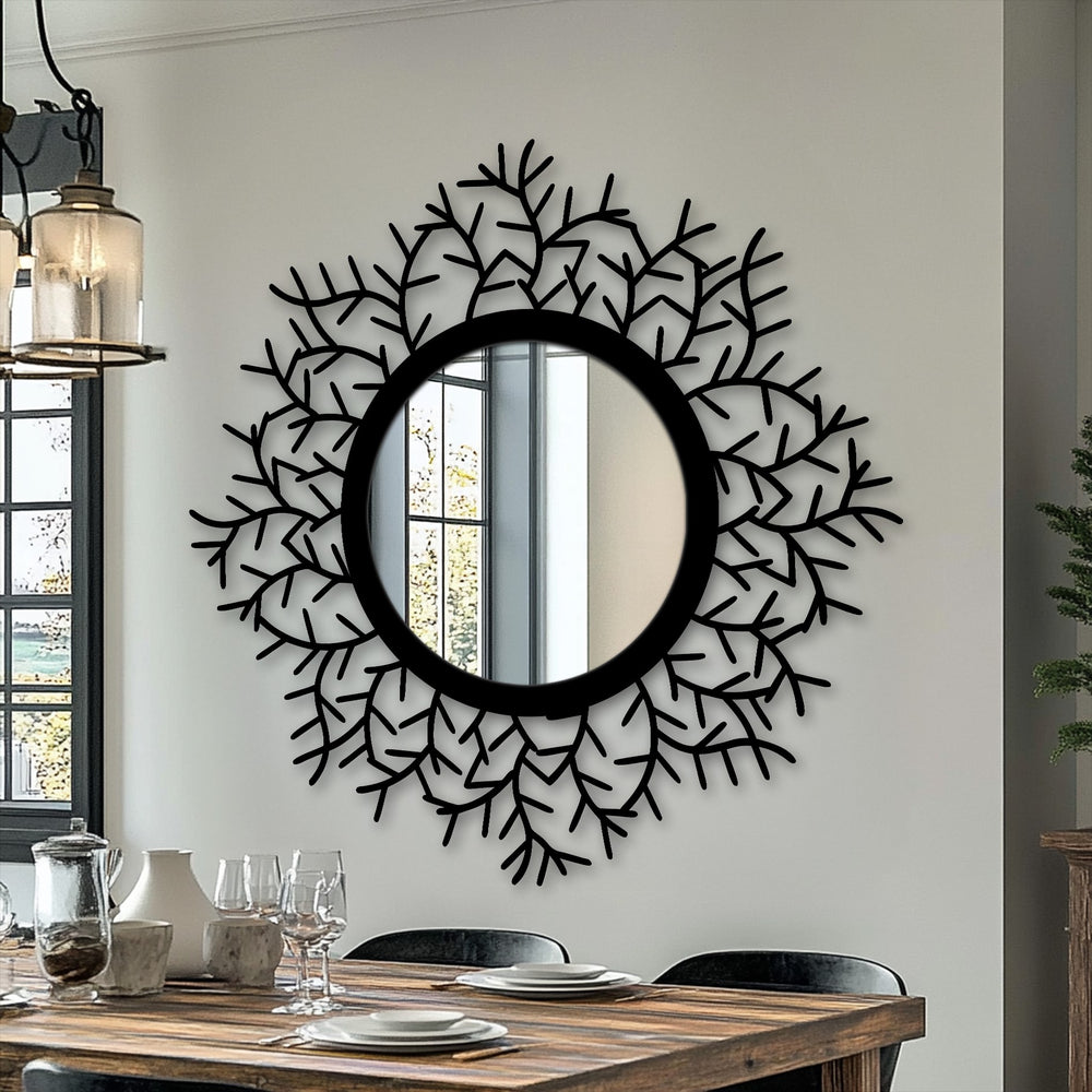 Black metal leaf accents highlight the focal point of this botanical halo framed wall mirror, an eye-catching piece of unique metal wall art.