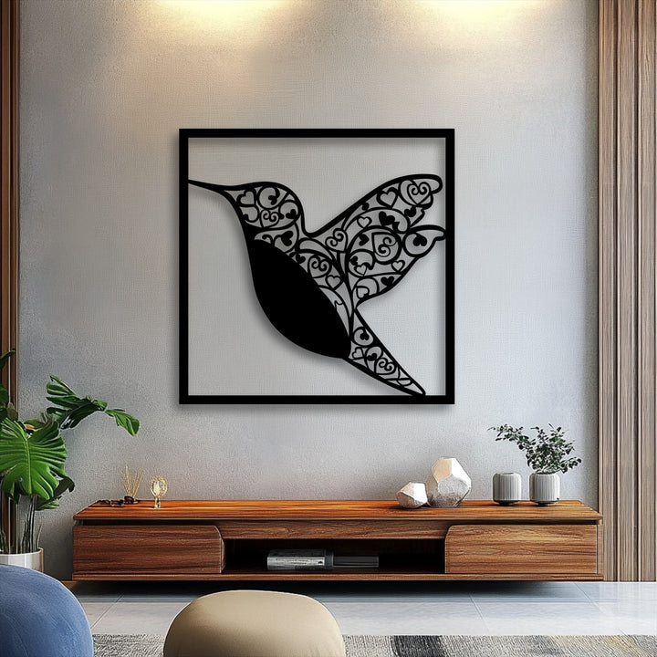 The darkest area reveals the intricate silhouette of the hummingbird adorned with ornate heart patterns, forming a stunning metal artwork.
