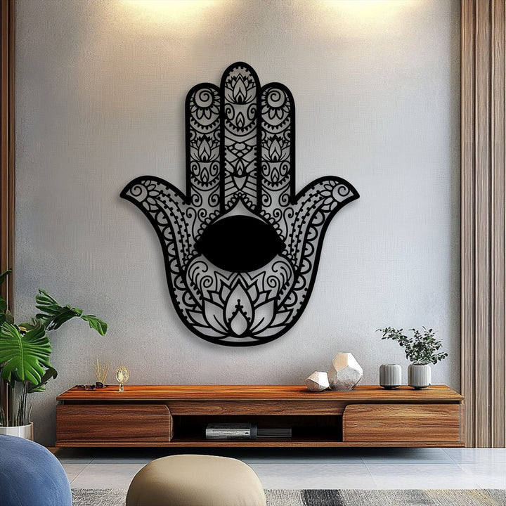 The intricately designed black Hamsa Hand metal wall decor, featuring an evil eye, serves as a striking focal point on a textured wall.