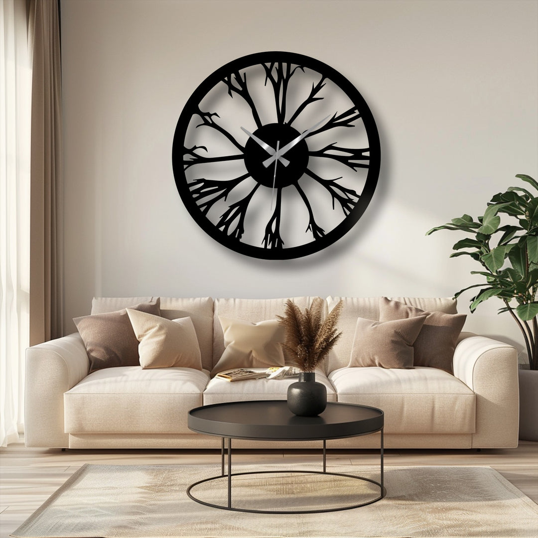 The intertwined, organic forms of the tree silhouette create a striking decorative metal art clock, casting intriguing shadows on the wall.