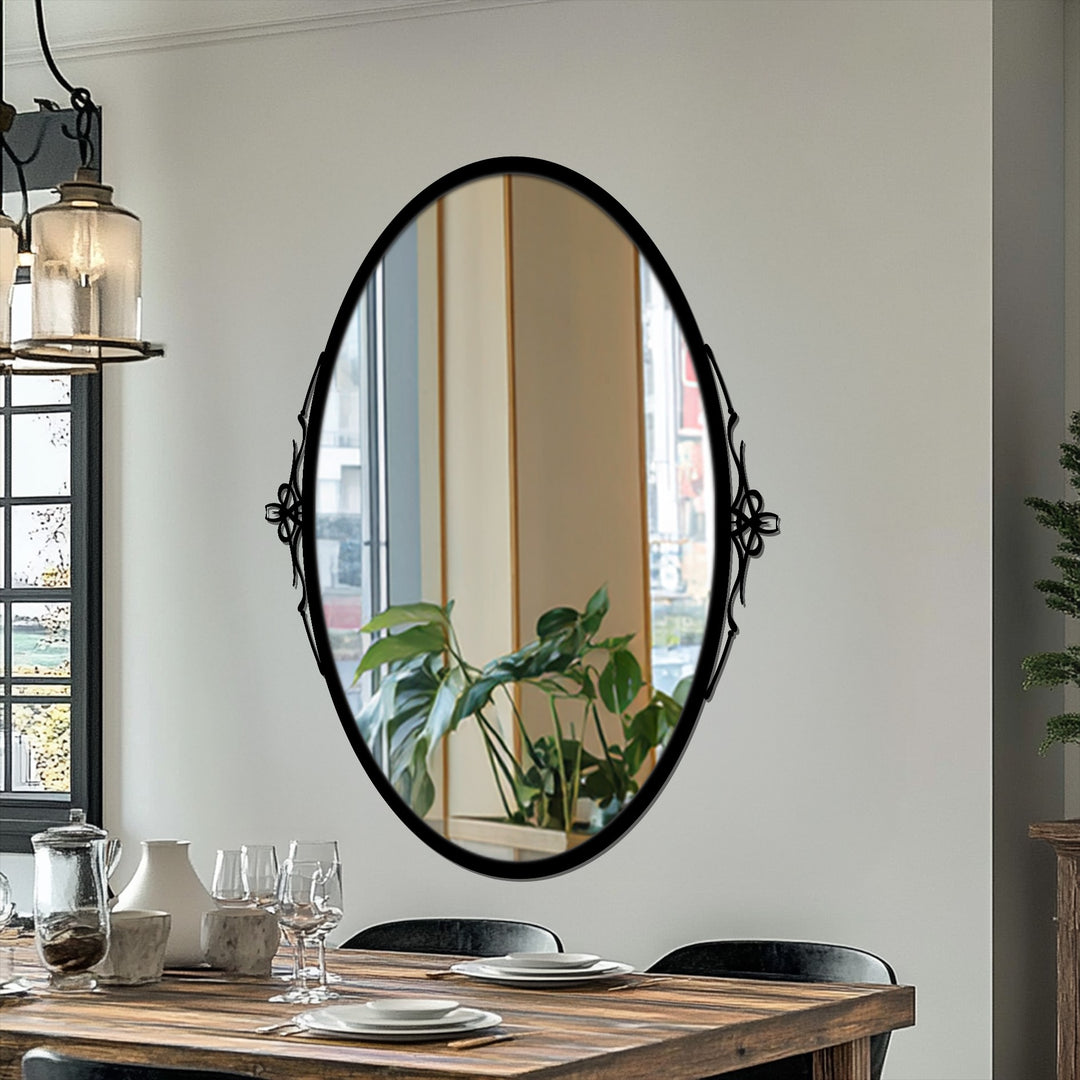 High color contrast highlights the black framed wall mirror against a light wall, reflecting a bright window and indoor plants for an elegant design.