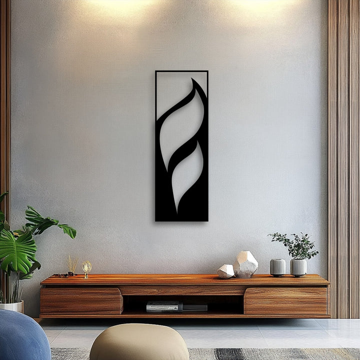The moderate color saturation of this metal art for wall highlights a striking black flowing leaves design against a subdued grey wall.