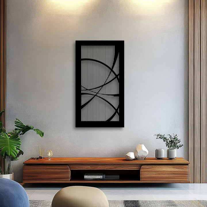 Organic forms featuring fluid, curving lines intertwine within the striking black framed metal artwork, creating a dynamic abstract design.