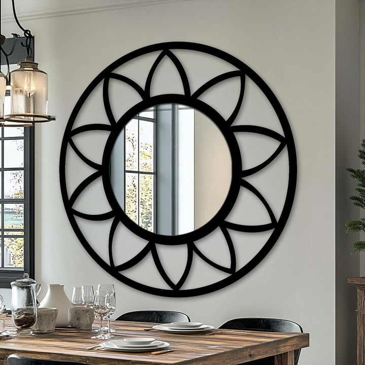 Negative space highlights the intricate petal design surrounding this round framed wall mirror, creating a captivating and modern focal point.