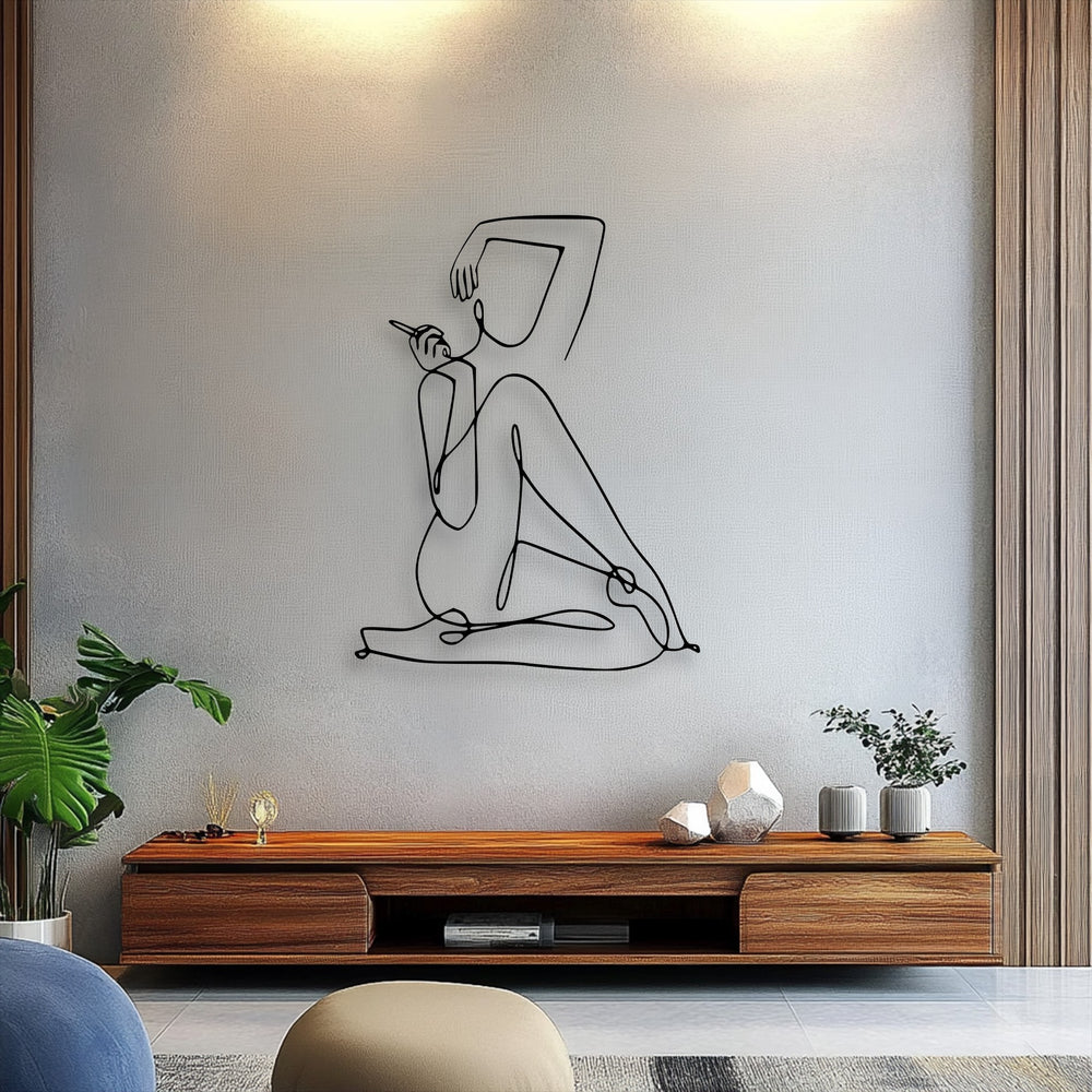 Focusing on the elegant abstract figure, this unique metal wall art features a minimalist female line drawing in black on a light grey wall.