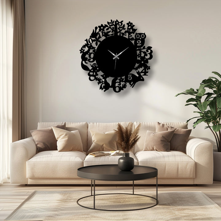 Illuminated by a nearby window, the white wall showcases a striking black metal wall clock featuring woodland animals and a forest nature design, enhancing home decoration.