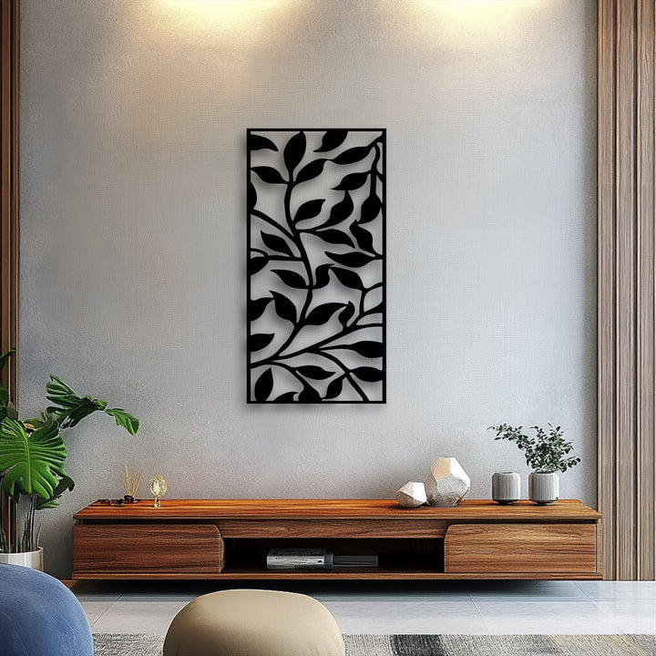 Striking color contrast in this unique metal wall art featuring a monochromatic black abstract leaf branch pattern against a light grey wall.