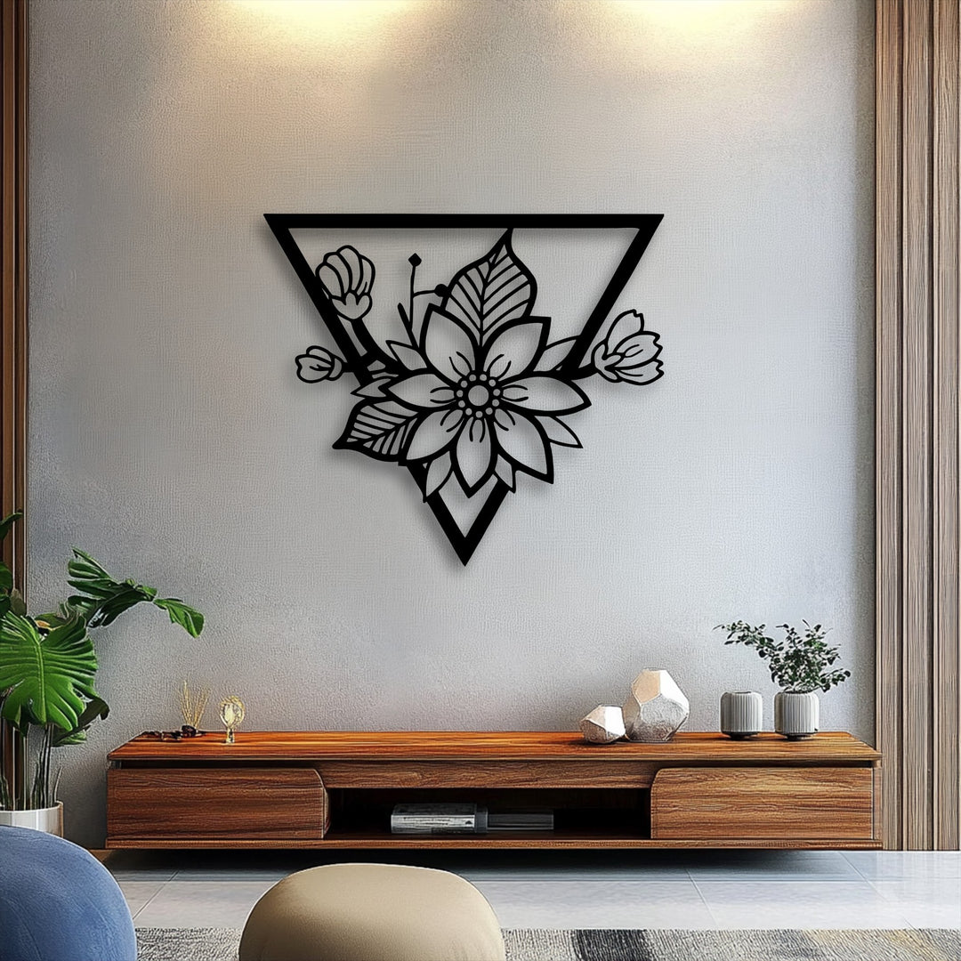 The soft, intricate petals of the floral blossom within the modern geometric triangle frame create a striking piece of decorative metal art.