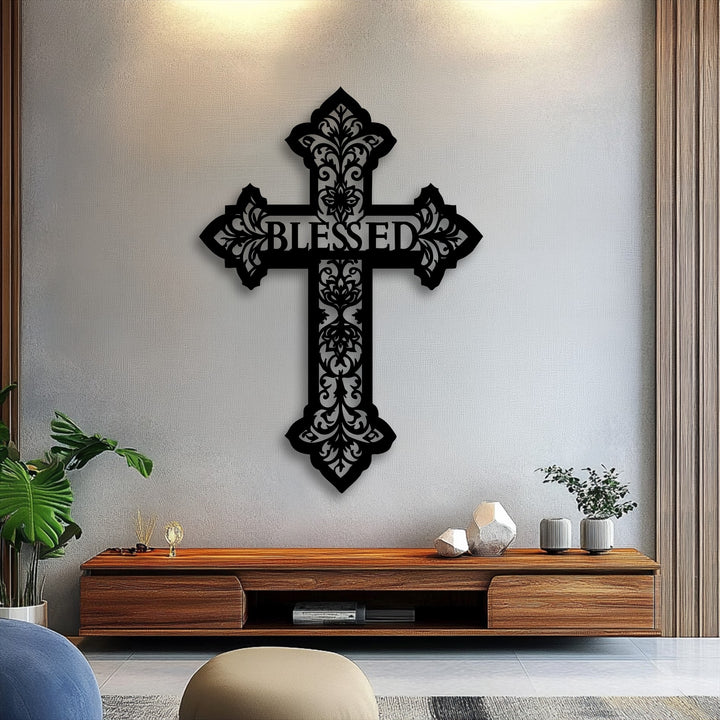 Dramatic light and shadow play across the intricate black metal artwork of a 'Blessed' cross, highlighting its detailed ornate design.