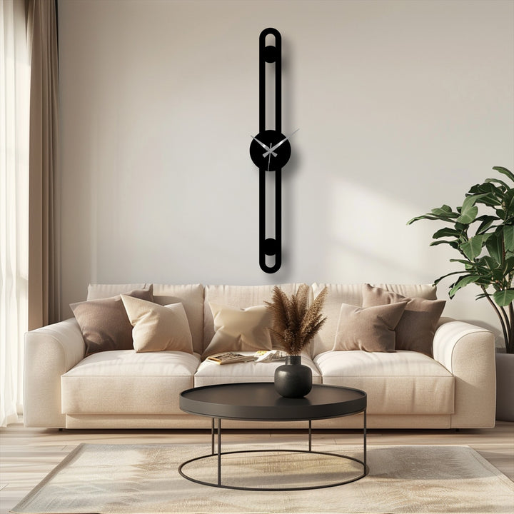 Foreground displays a round, dark coffee table with a slim line minimalist metal clock above a sofa, exemplifying decorative metal art.